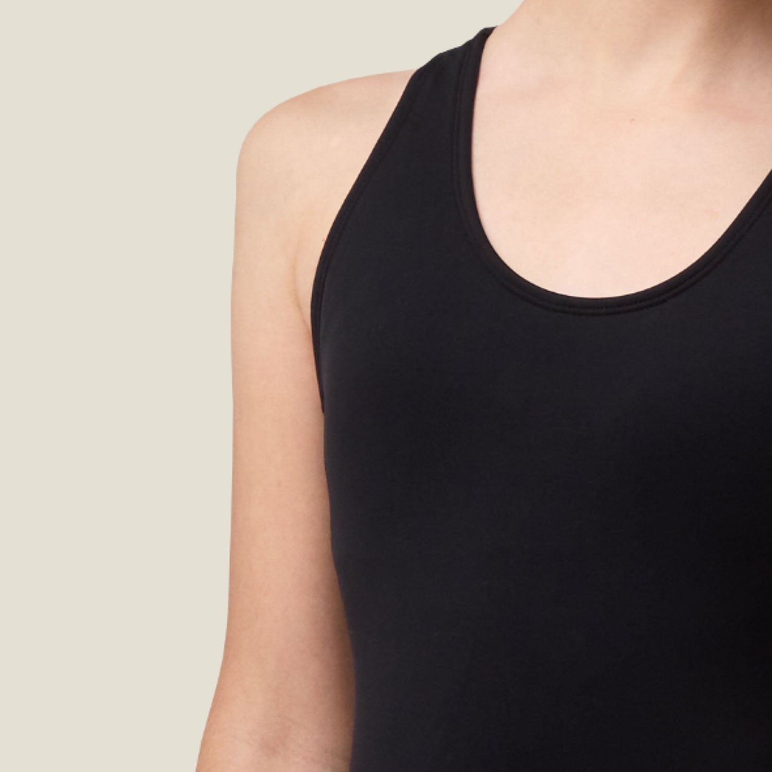 Close-up of the soft, smooth fabric and durable stitching on the black Teen Period Racerback Swimsuit for medium flow.