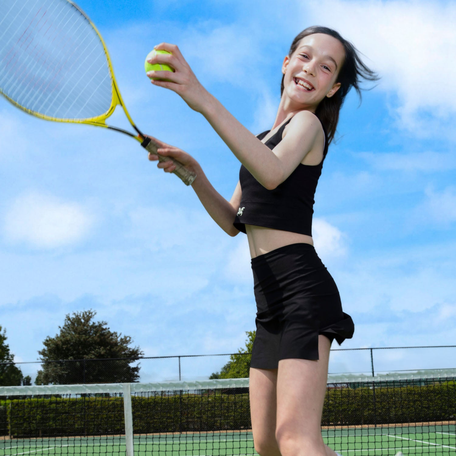 Teen playing tennis in navy WUKA Period Skort — leak-proof protection built for movement and fun.
