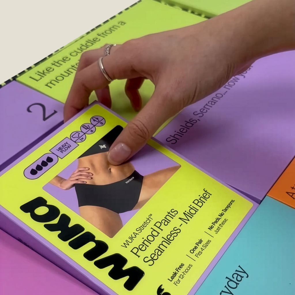 Hand revealing WUKA Adult Seamless Midi Brief Period Pants inside the Period Positive Advent Calendar