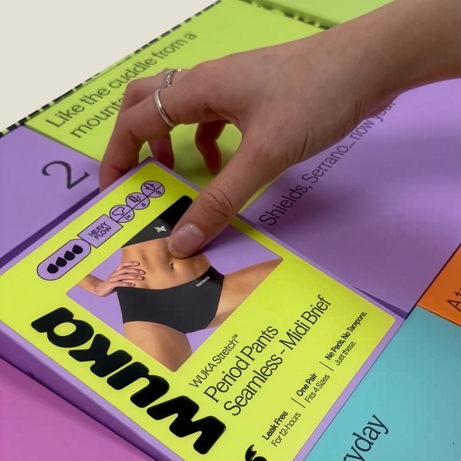 Hand revealing WUKA Adult Seamless Midi Brief Period Pants inside the Period Positive Advent Calendar