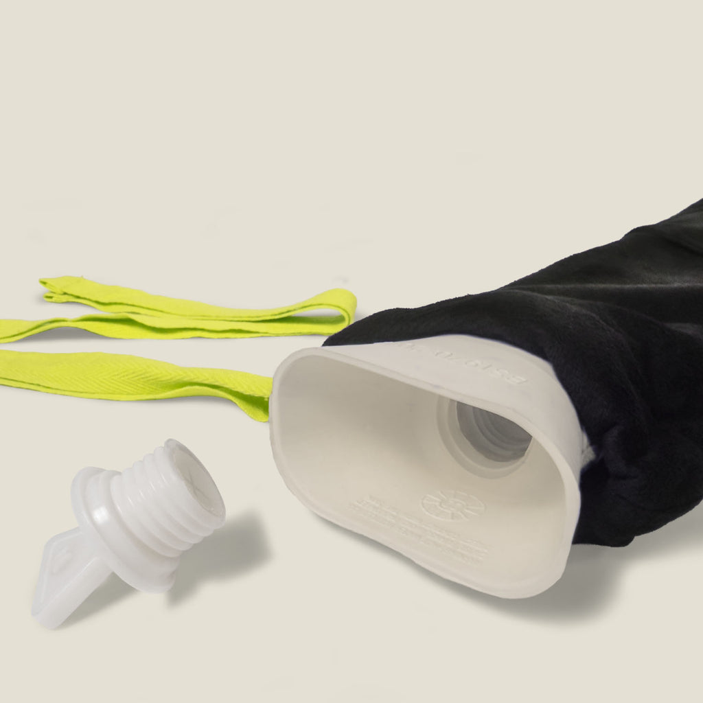 WUKA long hot water bottle opened with stopper placed beside, showcasing soft fleece wrap and neon tie straps
