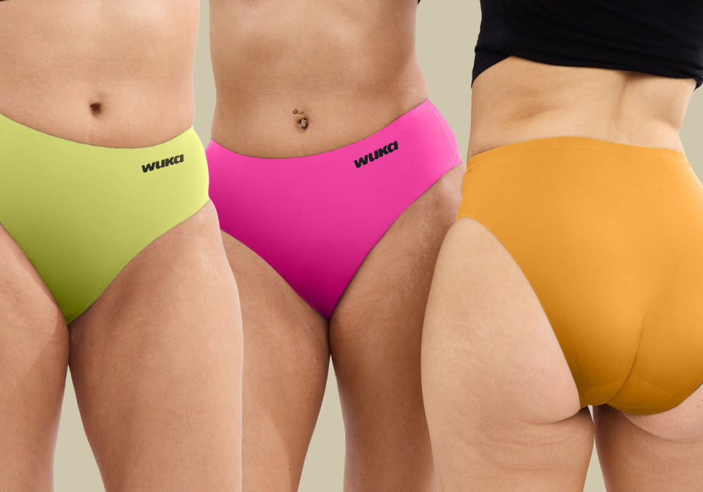 Close-up of three teens wearing WUKA Stretch period underwear in bold mood-boosting colours—lime punch, pinkest pink, and orange sun—designed to grow with teens and stretch up to 3 sizes for ultimate comfort and leak-proof protection